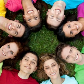 Happy smiling group of young friends staying together outdoor in the park