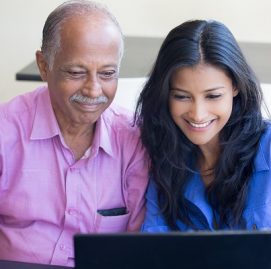 Homem idoso ao lado de mulher aprendendo no computador