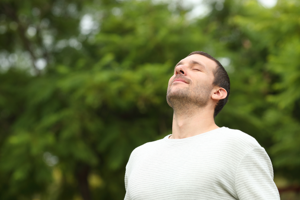 Homem respirando em um parque