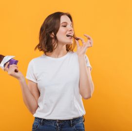 Mulher comendo chocolate para ilustrar os benefícios do alimento para o cérebro
