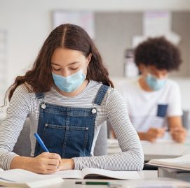 Menina escrevendo em um caderno na escola