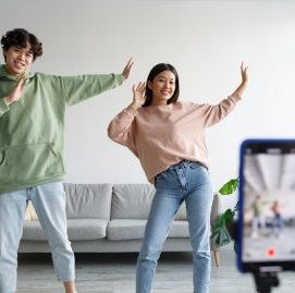 dois jovens dançam em frente o celular