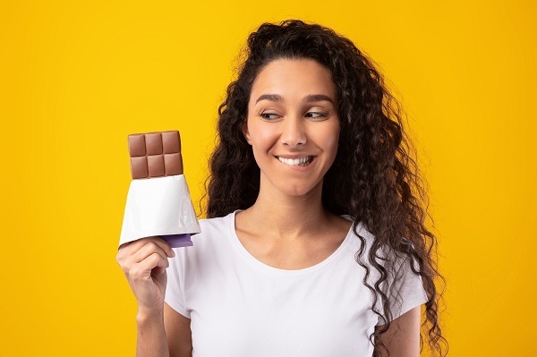 Mulher sorri enquanto segura chocolate