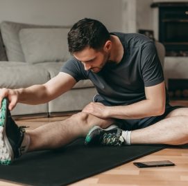 homem faz ginástica sentado no chão