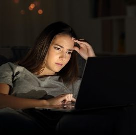 Mulher diante do computador a noite