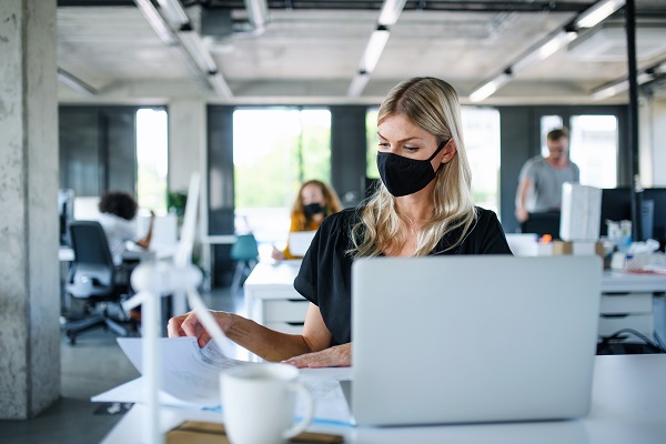 Mulher de máscara no ambiente de trabalho como ter motivação na volta ao trabalho