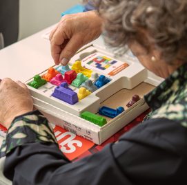 Idosa jogando Hora do Rsuh, jogo analógico que estimula o cérebro